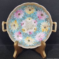 Front view of antique Royal Kinran Crown Nippon hand painted porcelain bowl showing floral decoration and scalloped gold rim with handles.