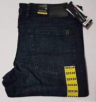 Folded black/dark wash denim Buffalo David Bitton Jack-X slim-straight men's jeans showing back pocket and size tag 32x34 with original tags attached.