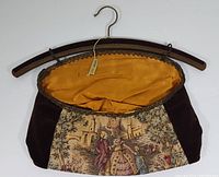 Front view of vintage Lilo Schilke hanging lingerie bag open, showing tapestry front and satin interior, attached to wooden hanger with metal hook.