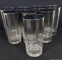 Front view of 8 vintage silver fade mercury highball glasses arranged in two rows against black background.