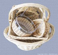 Top-down view of six wicker baskets stacked inside each other; various shapes and sizes including one with metal wire frame
