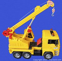 Side view of the yellow Bruder Tele-Crane TC 4500 toy crane truck showing the cab, 360 swivel boom, and hook.