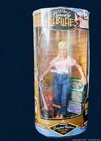 Front view of the doll and original packaging showing the figure and wear on the box.