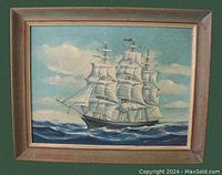 Full view of the wood framed painting showing the sailing schooner on the ocean with clouds in the sky