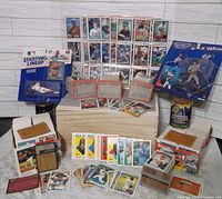 Wide view of the lot showing hundreds of baseball cards, multiple unopened vintage card boxes, and Starting Lineup figures in packaging.