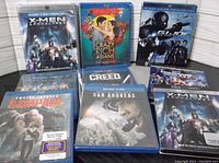 Nine Blu-Ray and DVD movie titles displayed, some still sealed, including X-Men, Rampage, and San Andreas.