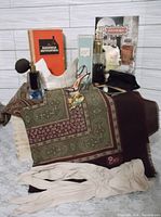 Photo of assorted vintage perfume bottles, fashion accessories including an AS scarf, cream gloves, jewelry, and a white display stand.