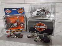 Four Harley-Davidson collectible motorcycle models displayed with two still in packaging and two unboxed models.