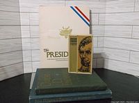 Photo shows four books stacked, with the Abraham Lincoln book standing upright showing the cover.