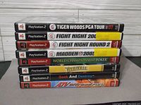 Stacked spines of 8 PlayStation 2 games showing titles and condition