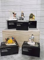 Five vintage Sebastian Miniatures figurines arranged on black boxes with branding.