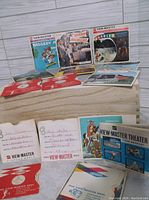 Seven View-Master reels with original sleeves, including Beverly Hillbillies, Raggedy Ann, Barbie, Ringling Bros Circus, Blue Ridge Parkway, Hawaii, Pennsylvania, showing vintage 1960s packaging and reel disks.