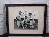 Framed black and white photograph showing Ted Williams in a Red Sox uniform, Yogi Berra and Mickey Mantle in Yankees uniforms posing with bats and catcher's glove on baseball field.
