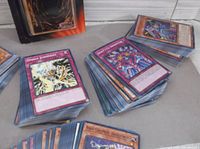 Close-up of stacks of loose Yu-Gi-Oh! cards showing 'Omega Judgment' trap card, 'Special Summon' monster card, and others.