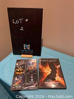 Display of two DVD cases: one is the Batman Begins DVD used copy; the other is an unopened DVD set featuring 4 Batman favourite movies.