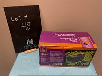 Photo showing the boxed fog machine lot, labeled lot 48, with retail box details visible.