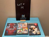 Full lot photo showing all three DVD cases standing upright: The Amazing Spider-Man, Superman 4-movie set, Catwoman.