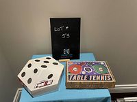 Two boxed games: Yahtzee Free For All in a white 12-sided die-shaped box with black dots, and Table Tennis game in a rectangular box with colorful paddle and ball design.