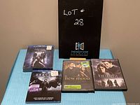 Lot shot with all DVDs and Blu-rays displayed on table. Includes Vampire Diaries Season 4, Dracula Untold, Twilight, and New Moon.