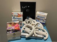 Photo showing the Wii games Racquet Sports, Zumba Fitness Core, and the Wii Sports Resort game box with multiple Wii controllers and attachments.