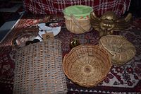 Four baskets, wooden snowman decoration, gold angel figurine on carpet