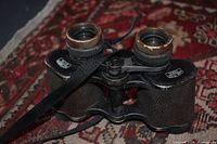 Close-up photo of vintage binoculars showing texture and metal rims with wear