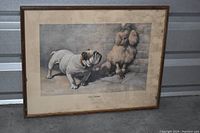 Framed vintage print featuring a bulldog and a poodle with visible aging on mat board and frame.