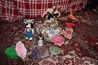 Full lot overview showing all figurines and decorative items on a patterned rug.
