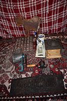 Overview of all lot items including grinders, candy mold tray, Wedgwood sign, and metal cow decoration on a pattern rug background.