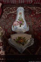 Both porcelain wall piece and planter on rug background