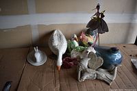 Photo showing ceramic duck figurines, colorful rooster, decorative birds, teapot and figurines.