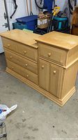 Full view of the maple wooden bureau with multiple drawers and cabinet door.