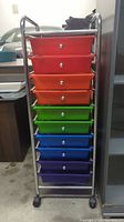 Full front view of colorful 9-drawer rolling storage cart showing the red, orange, green, blue, purple drawers and metal frame with casters