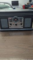 Overall view of the Victrola stereo system showing black woodgrain finish and front panel