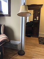 Full view of the antique bridge lamp in a room with wooden flooring, showing its height and overall condition.