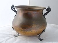 Side view of the vintage brass pot showing curved handles and flared rim