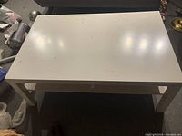 White IKEA coffee table top surface showing dirt and marks, rectangular shape.