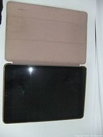 Front view of the iPad showing black screen and beige protective cover opened flat.