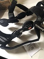 Close-up image showing the bottom of the black Breg knee brace with straps and size tag indicating medium women's fit.