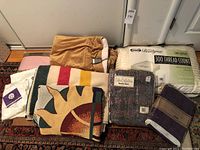 Full view of the lot with all blankets, pillowcases, sheet and pillow arranged on floor