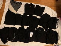 Overview of all sweaters laid out showing multiple styles and textures in black cashmere.