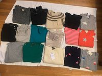 All 16 sweaters arranged on white sheet