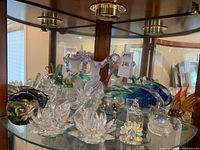 Wide view of shelf displaying all decorative glass and crystal pieces