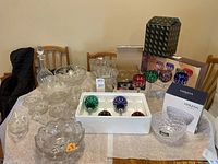 Full view of all items on table showing various clear cut glass bowls, colored crystal goblets, boxed Mikasa Palazzo bowl, glass decanter, and salt/pepper shakers.
