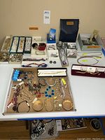 Overhead view of assorted bracelets, necklaces and earrings arranged in gift boxes and a cardboard tray