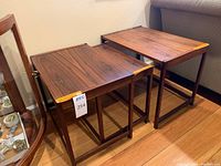 Three nesting tables side by side on hardwood floor next to sofa