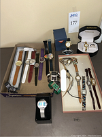 Top-down view showing various wristwatches in multiple styles and colors including boxed and unboxed pieces.