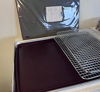 View of sheet pan, silicone mat, cooling racks, and cutting board stacked together.