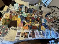 Overall view of assorted fabric pieces and paper patterns spread on bed