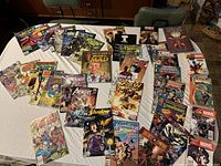 Overview of twice folded comics on a table showing multiple titles with colorful covers from Marvel, DC, and others